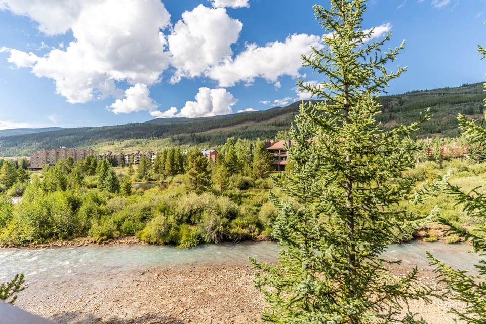 Mountain resort surrounded by pristine wilderness and flowing river, offering scenic natural beauty.