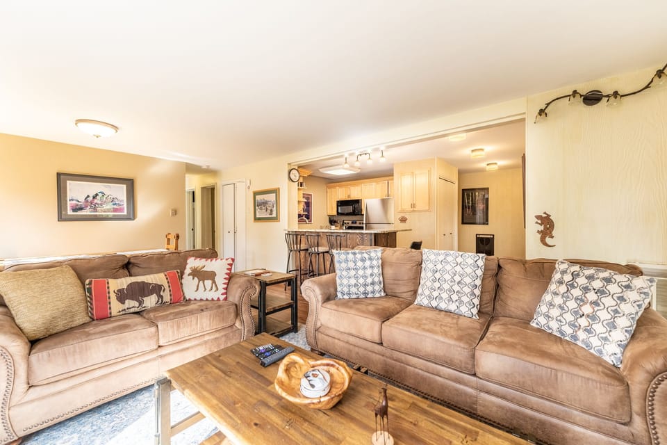 Sink into plush leather sofas where rustic charm meets modern comfort in your spacious living area, perfect for cozy evenings.