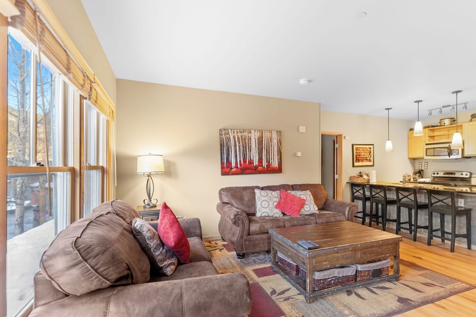 Cozy leather sofas and rustic coffee table create your perfect gathering spot, with open kitchen just steps away for easy entertaining.