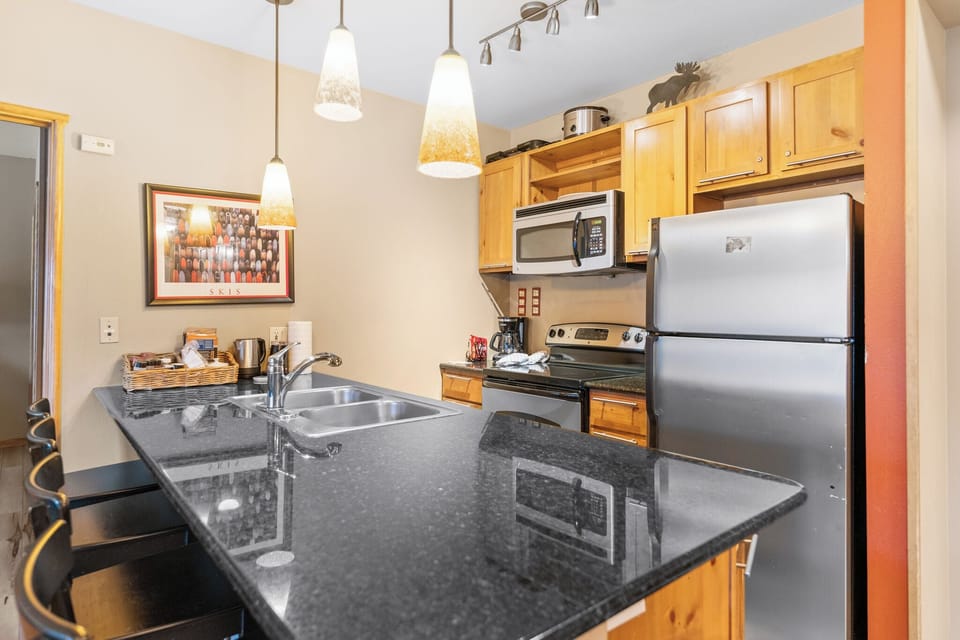 Your fully equipped kitchen features granite counters, stainless appliances, and warm lighting—perfect for preparing meals during your stay.