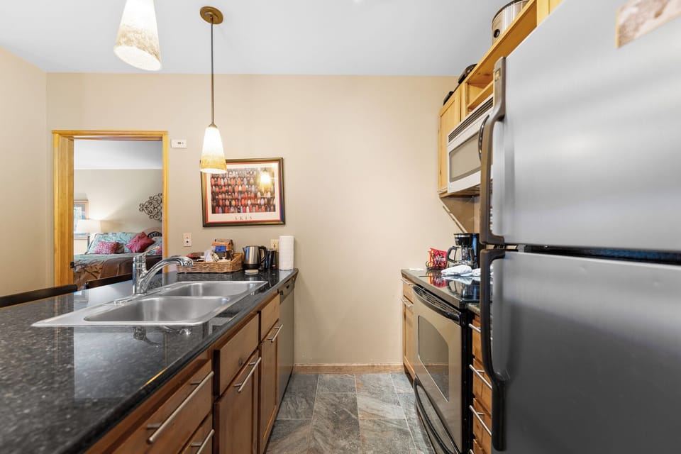 Your modern galley kitchen features sleek granite counters, stainless steel appliances, and warm wood cabinetry—perfect for preparing meals during your stay.
