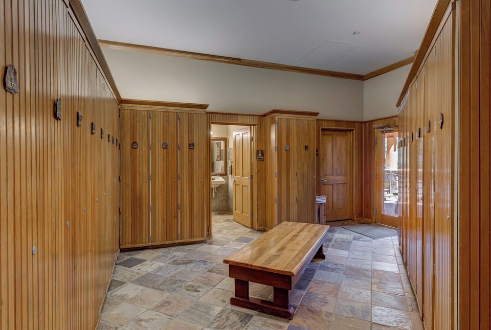 Your private changing room awaits with rich wood lockers and stone floors - perfect for storing gear after spa sessions or outdoor adventures.