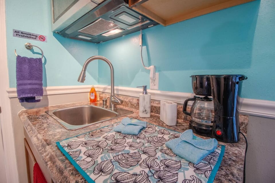 Kitchenette with microwave, coffee maker, sink and kitchen cabinets