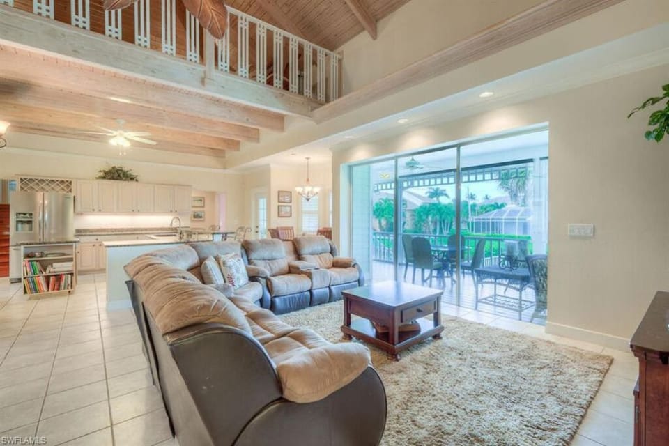 Living room with loft above and kitchen in the background