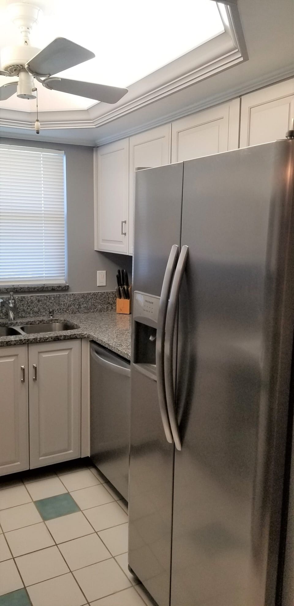 Stainless steel fridge and freezer, with ice maker and water dispenser in door. 