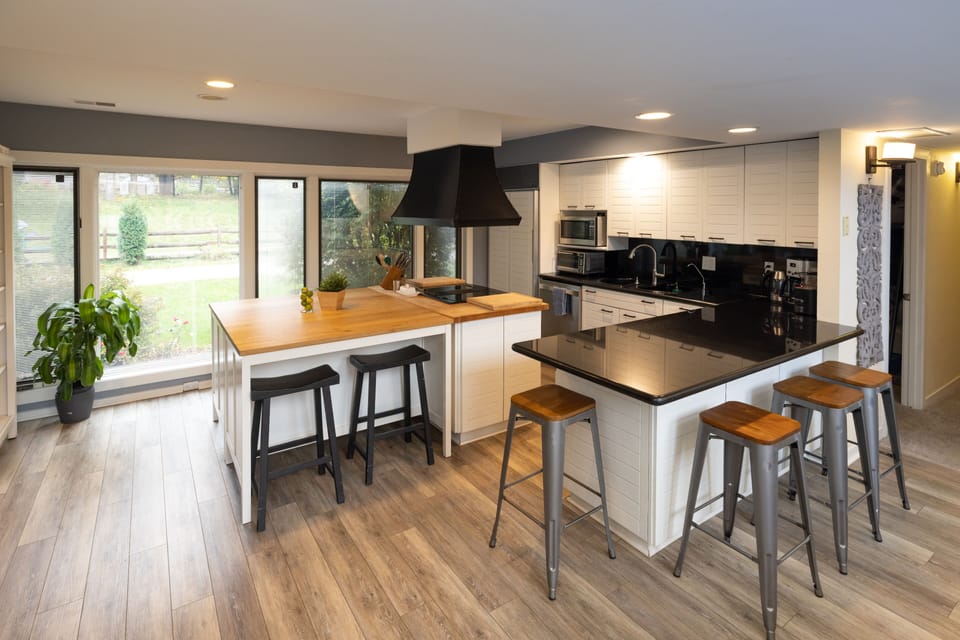 kitchen with 8 counter stools, open to living and dining rooms

