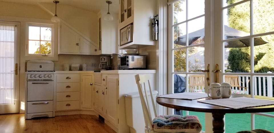 dining nook for 3 fronting double french doors looking out over private deck