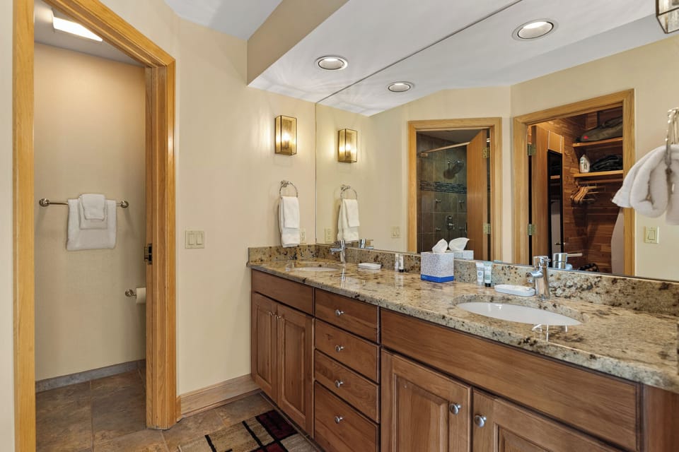 Pamper yourself in this luxurious master bathroom with dual vanities, granite countertops, and elegant lighting for your morning routine.