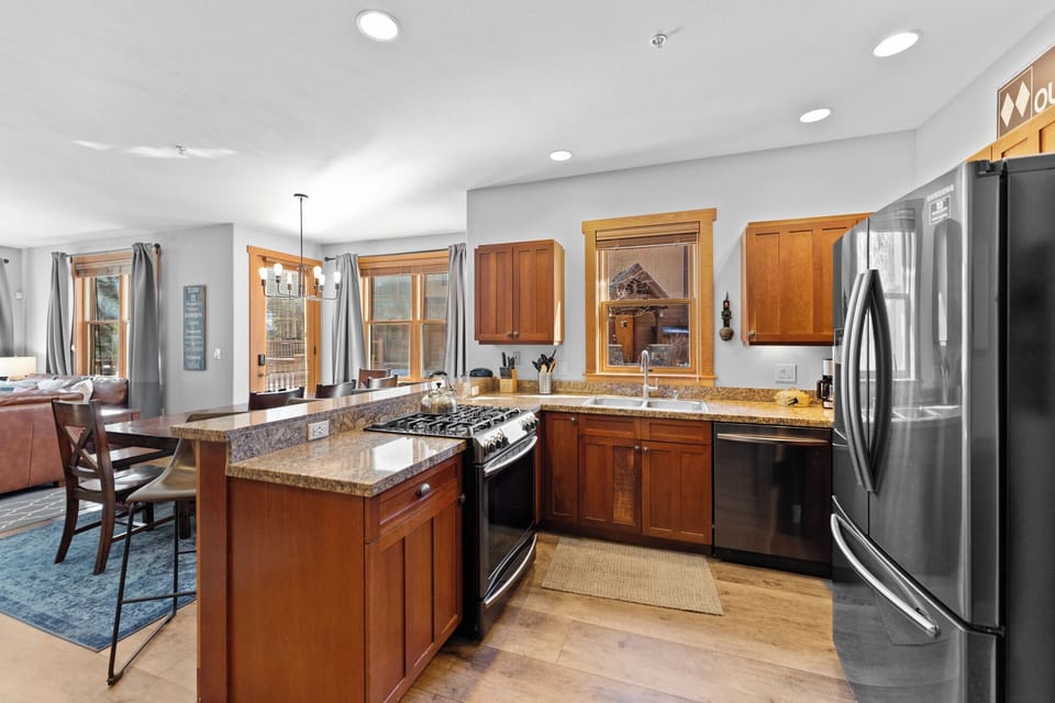 Cook with ease in this fully equipped kitchen featuring granite countertops, stainless appliances, and warm wood cabinetry.
