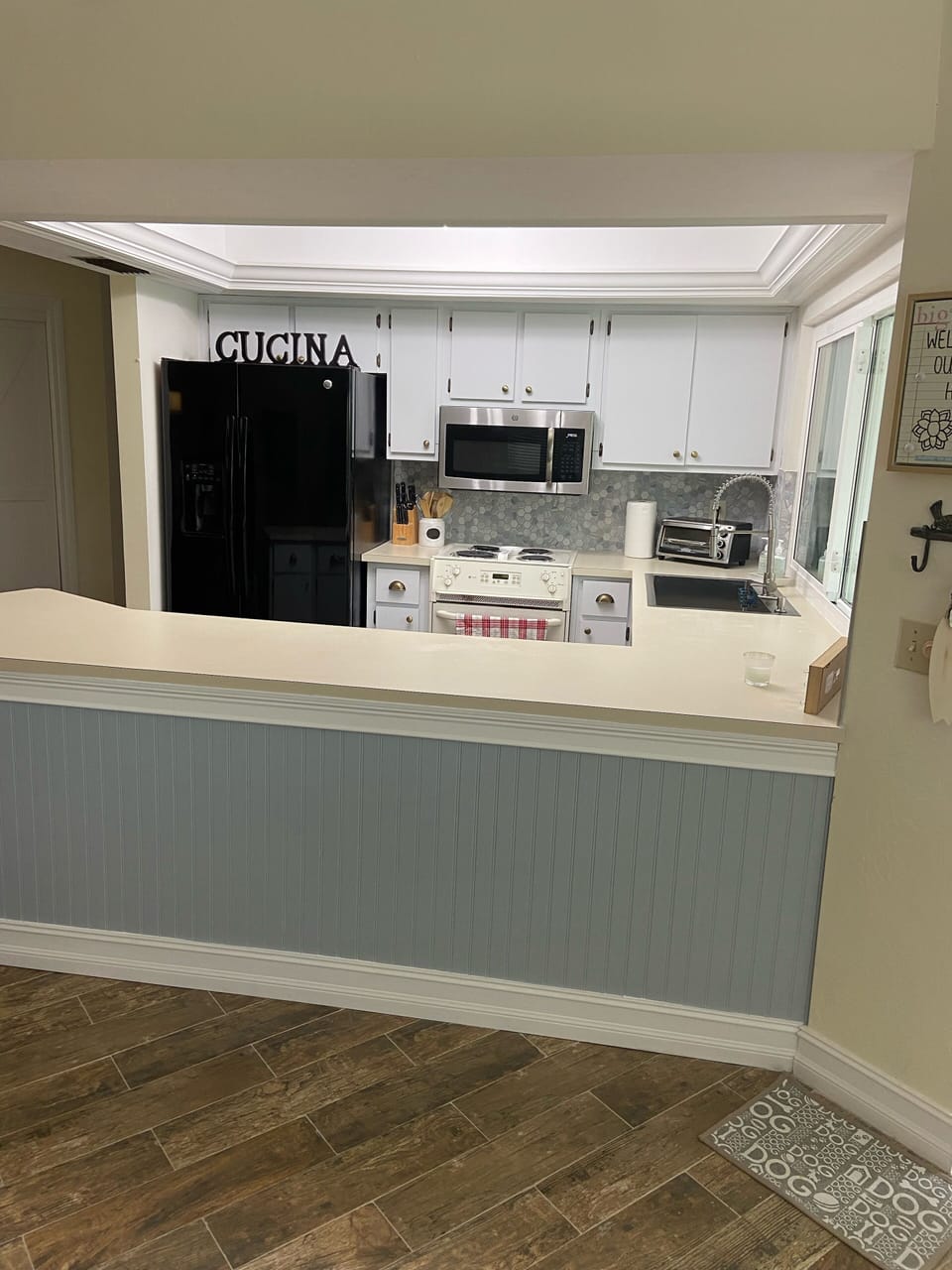 Refreshed kitchen with newly painted cabinets, new backsplash and floors. 