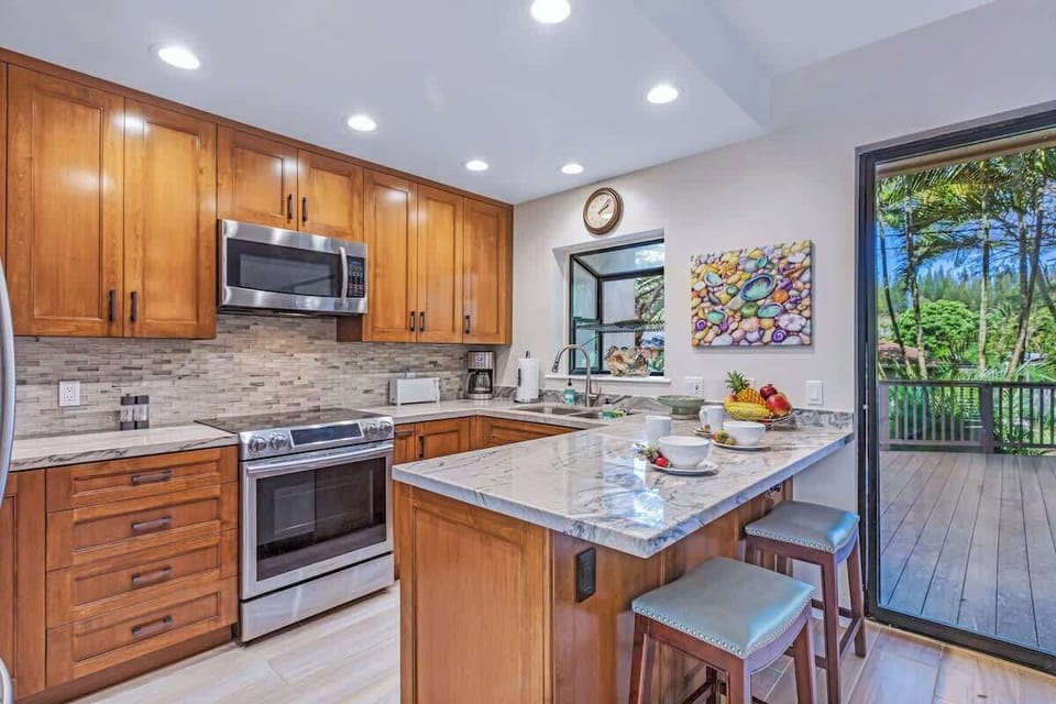 Cook delicious family meals in this modern Maui kitchen, complete with stainless steel appliances, granite counters, and bar seating. Save money by dining in, then step out to the tropical deck for al fresco meals surrounded by island beauty.
