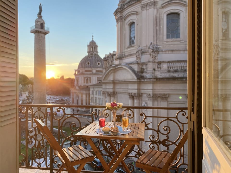 Balcony with table and chairs, perfect to enjoy Rome's sights from dawn to dusk.