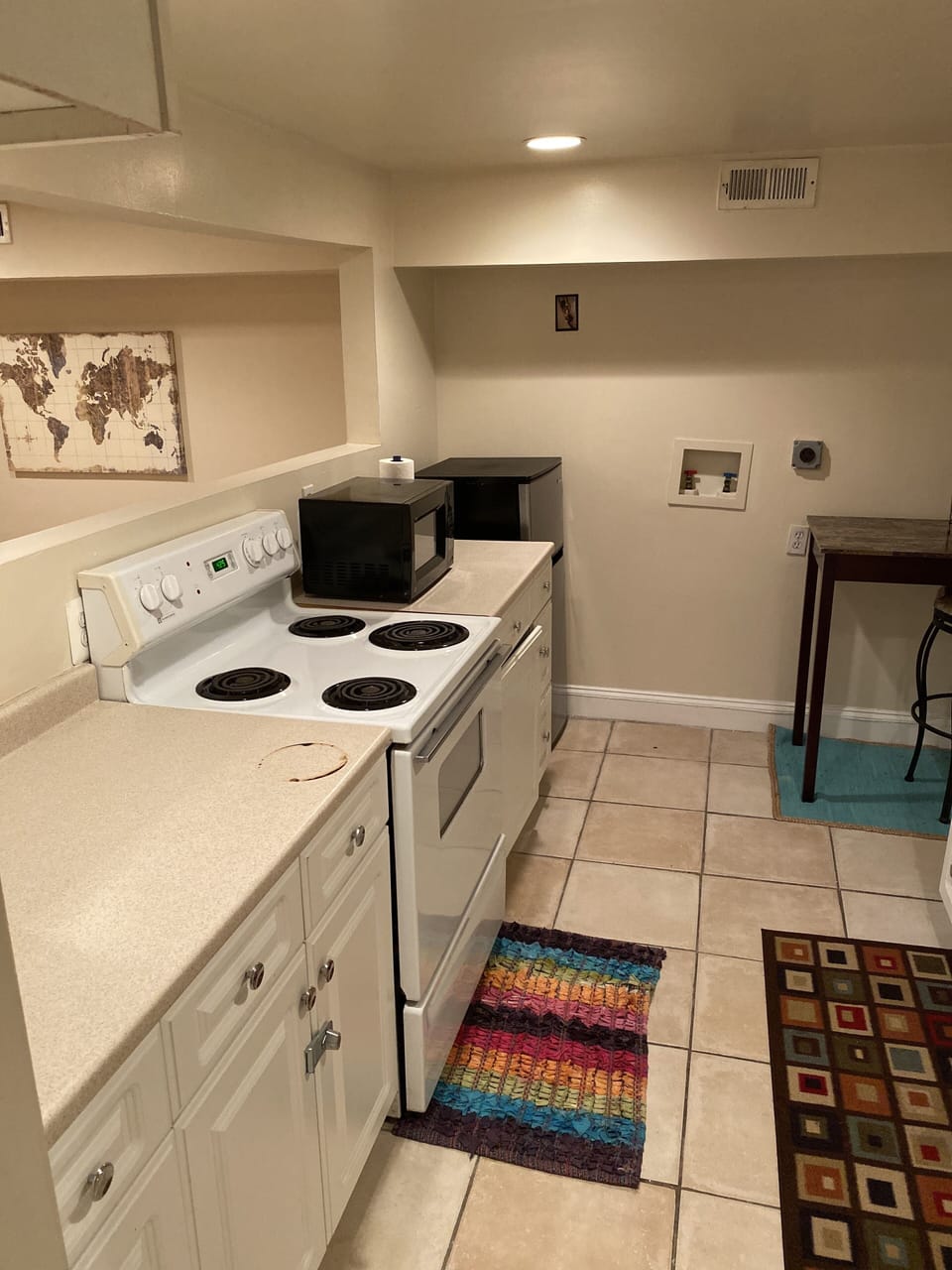 Functional basement kitchen with small refrigerator.