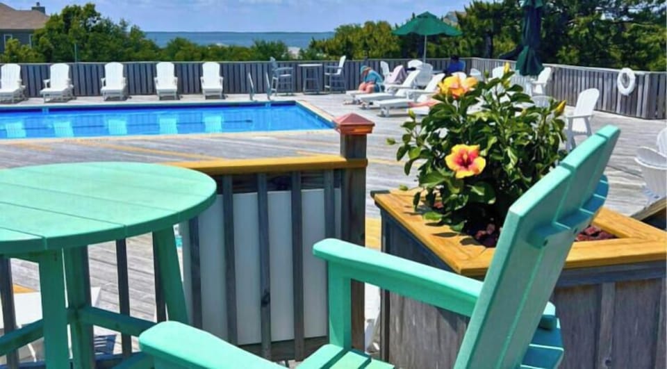 Relax by your sparkling community pool, where turquoise chairs and ocean views create the perfect sunny escape. Lounge on comfortable chairs, soak up the warmth, and unwind in this peaceful poolside retreat.