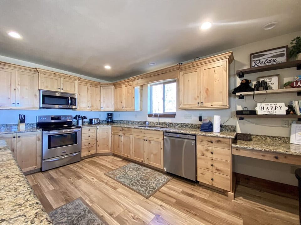 Charming kitchen with rustic wood cabinetry, granite countertops, and cozy décor for warm, welcoming vibes