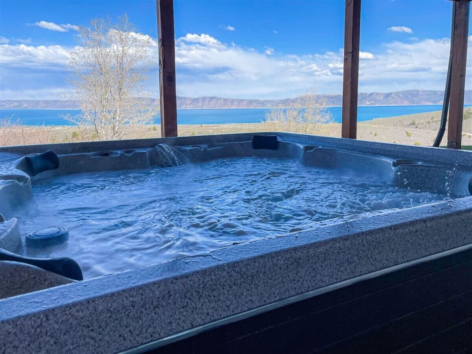 Soak in the bubbling hot tub while enjoying stunning panoramic lake and mountain views