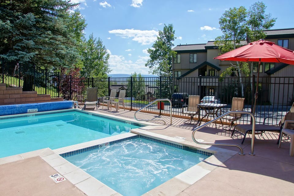 View of the pool and hot tub area with the condo in the background