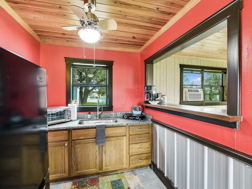 The guesthouse kitchenette includes a small refrigerator, toaster oven, coffee maker, and a two-burner stovetop unit.