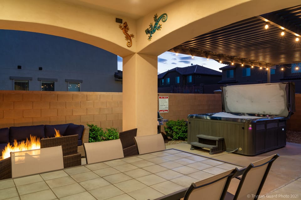 Patio featuring outdoor dining, fireplace, and hot tub