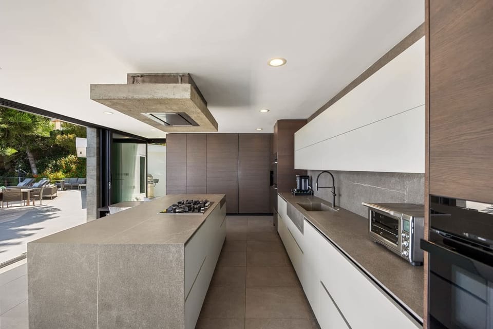 Sleek countertops and modern cabinetry offer ample storage and workspace, perfect for gourmet cooking.