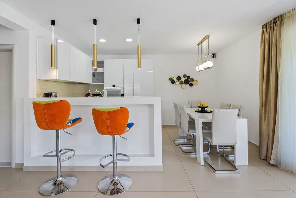 A fully equipped kitchen next to the living room and dining area
