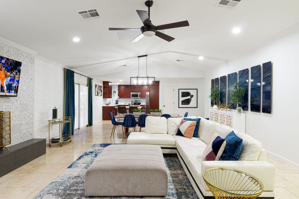 Beautifully designed open floor concept living room featuring comfortable seating, fireplace, and a smart TV.