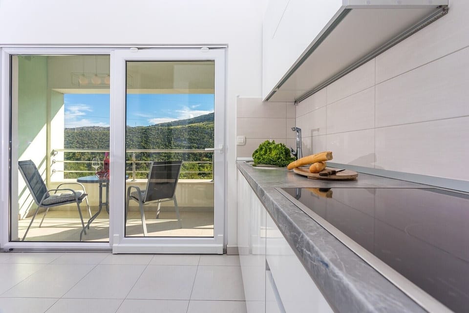Fully equipped kitchen with dining & living area and exit to tthe terrace