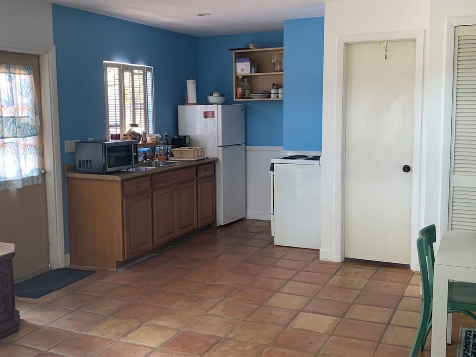 Kitchen next to front door and door to bathroon