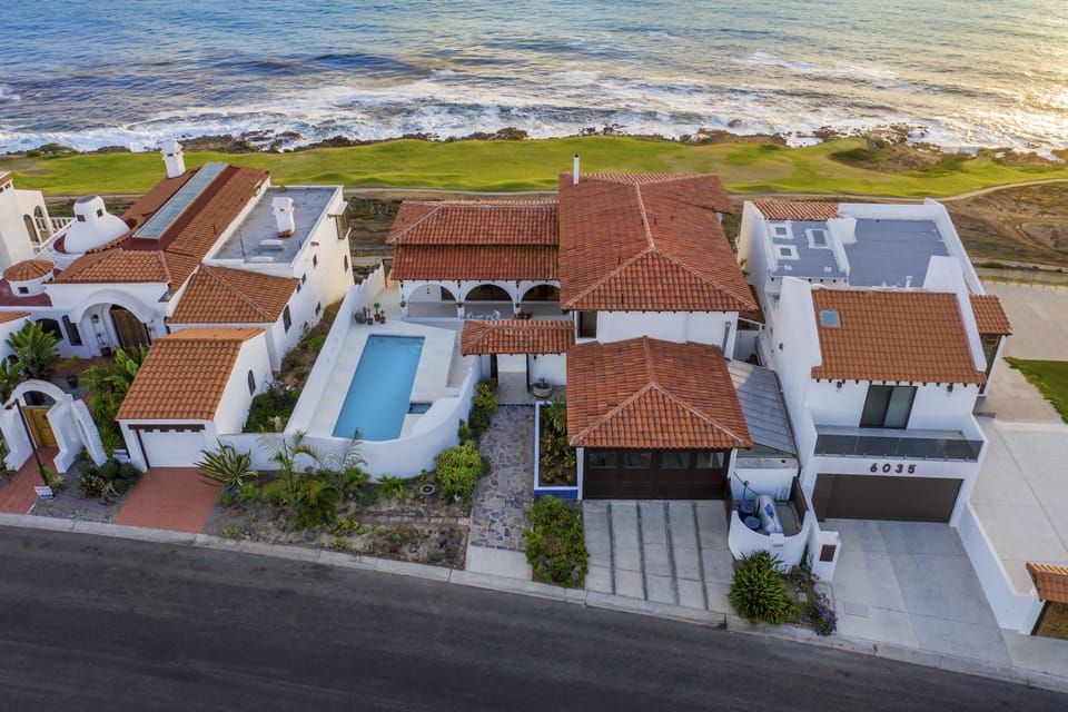 Birds eye showing the property, pool, and proximity to the fairway lined ocean