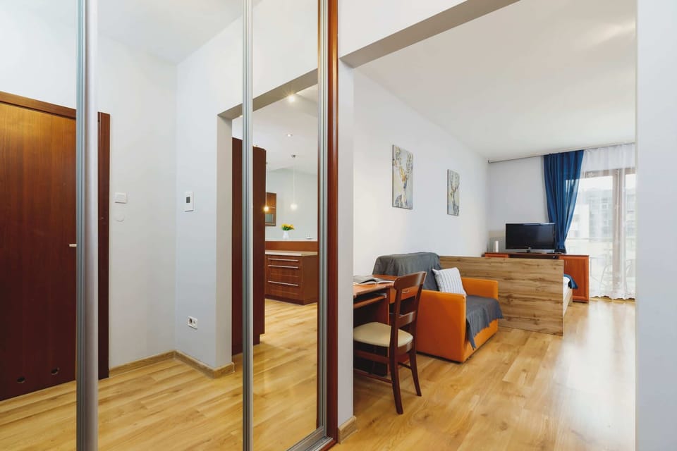 A compact kitchenette connected to a small dining area, decorated in warm wood tones.