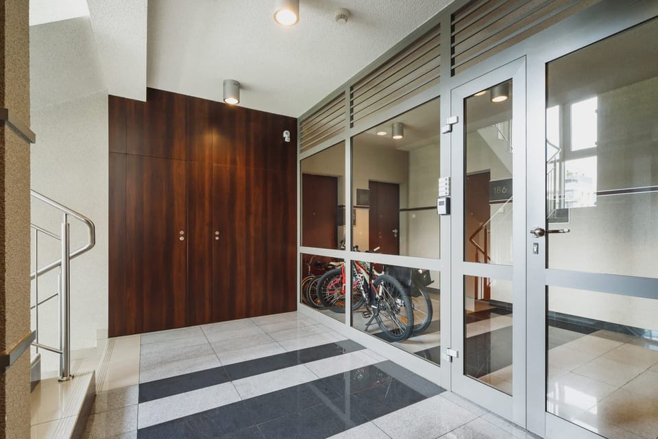 A bright hallway with wooden floors, a closet, and doors leading to different rooms in the apartment.