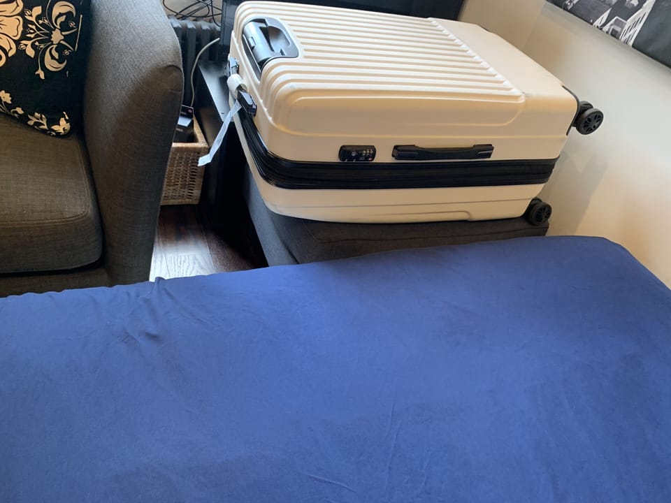 Ottoman meant to hold your suitcase!  At the foot of the bed. 