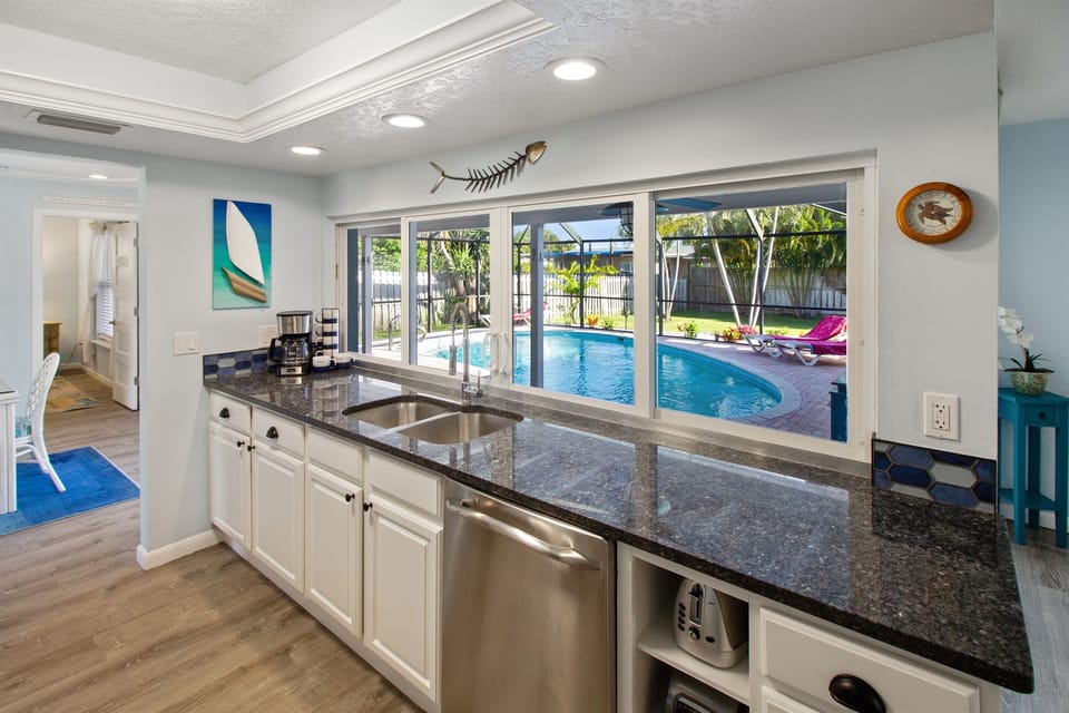 Kitchen overlooks pool and has sliding pass-through window