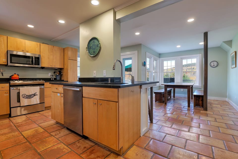 Large Kitchen with gas range, dishwasher, sink. Door off to deck with grill