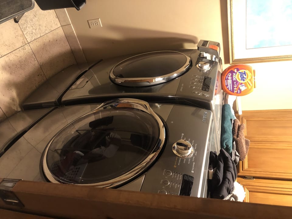 Front loader Samsung Washer Dryer in separate laundry room. 
