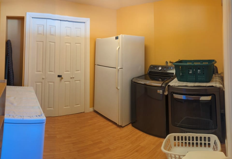 Laundry room with full size washer, dryer and a freezer.