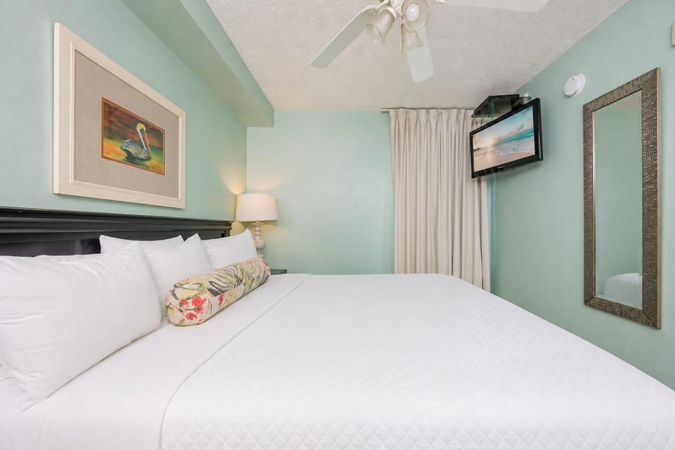Fluffy pillows invite you to relax in the king suite for a calm movie night after a fun day at the beach