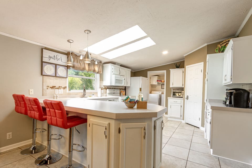 Large bright kitchen with frig,stove,microwave,crockpot, blender,pots and pans.