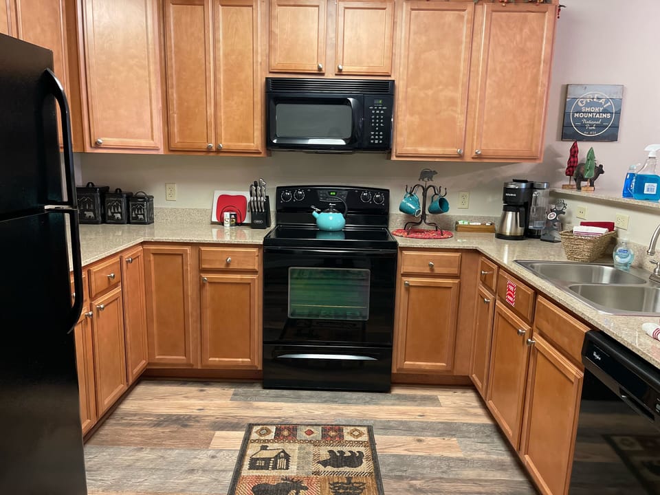 Kitchen with oven, stove, dishwasher, fridge with ice maker and Keurig coffee. 