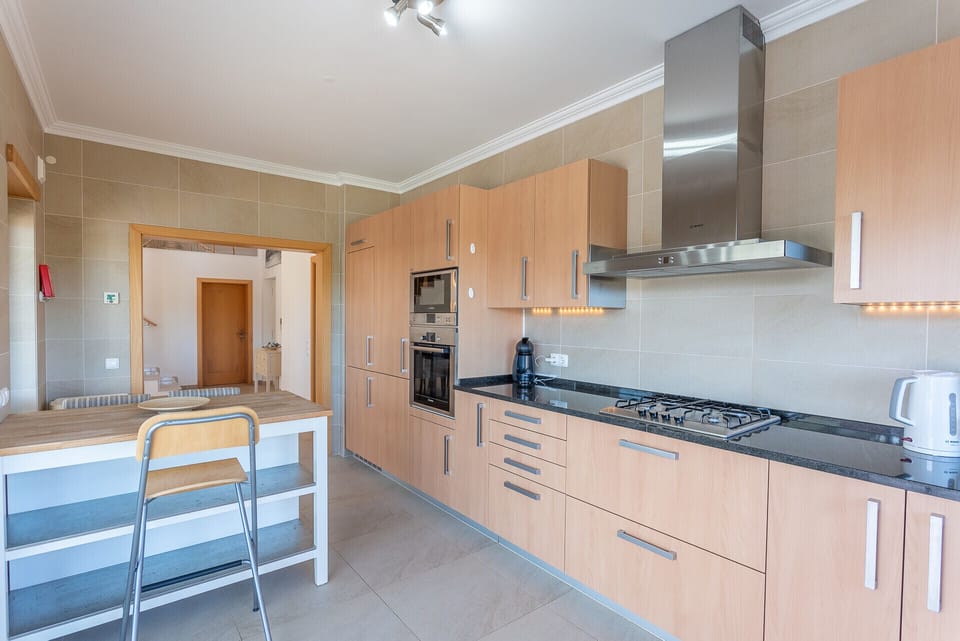Modern kitchen with wooden cabinetry and black granite countertops — Villa del Rey VII, holiday villa in Óbidos