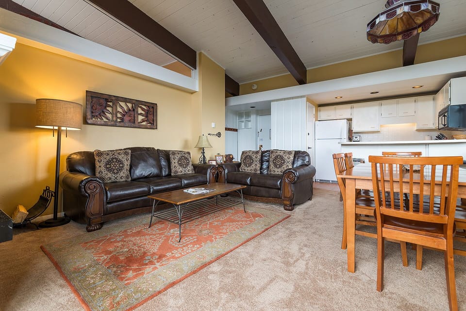 Sink into plush leather sofas in your open living space, where exposed beams and warm lighting create the perfect atmosphere for relaxing evenings.