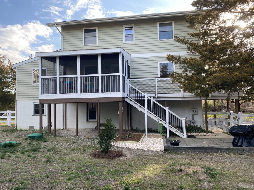 Side screened porcth, fenced area for dogs and stairs to main living level