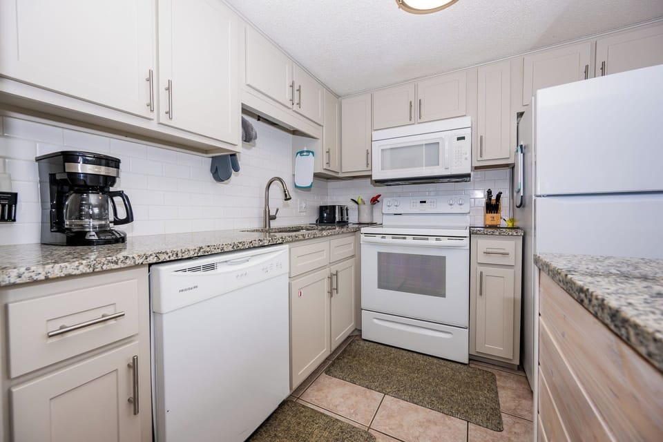 The kitchen features sleek cabinetry, granite countertops, and essential appliances, perfect for preparing meals