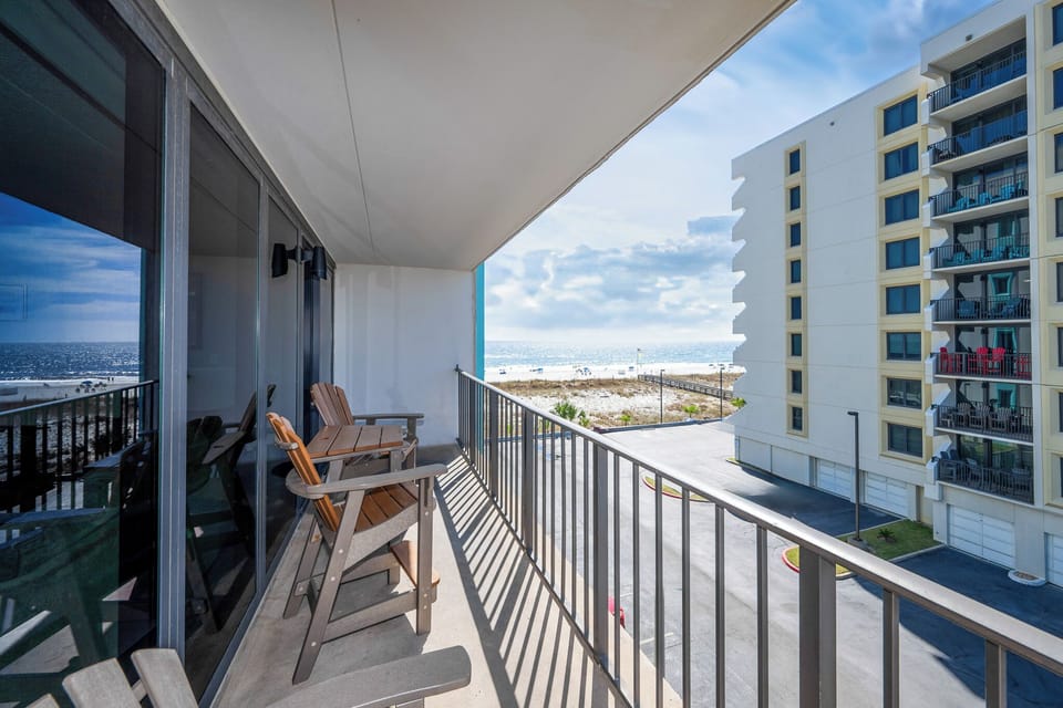 Enjoy breathtaking views from this inviting balcony with comfortable seating, perfect for relaxing by the beach