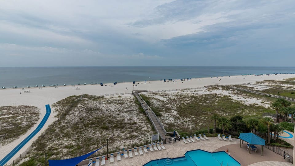 Enjoy the expansive view of the beach with lounge chairs and umbrellas, perfect for a relaxing day in the sun