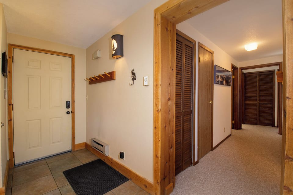 Step into your welcoming entrance featuring warm wood accents and rustic charm, leading to your comfortable retreat.