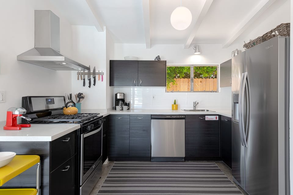 Bright fully stocked kitchen with stainless steel appliances and quartz counters