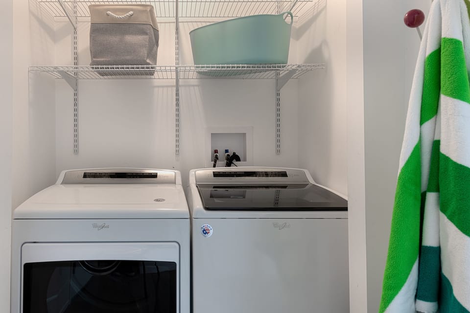 Full size Whirlpool washer and dryer in dedicated laundry area near kitchen