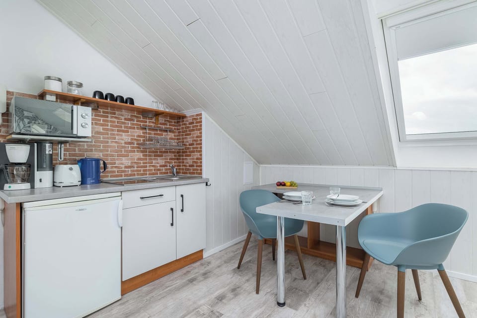  Kitchen area with white cabinets and a dining table.