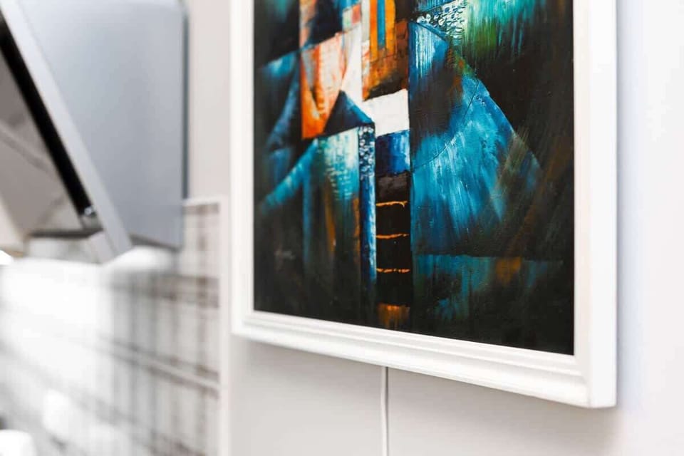 A framed piece of modern artwork displayed on the wall in the living room, adding character to the space.